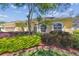 Lovely yellow home with lush, well-maintained landscaping, featuring vibrant shrubs and a neatly manicured lawn at 2712 Clubhouse Dr, Plant City, FL 33566