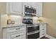Modern kitchen featuring stainless steel appliances, granite countertops, and stylish white cabinetry at 2712 Clubhouse Dr, Plant City, FL 33566