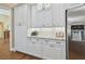 Kitchen features elegant white cabinets, granite countertops, and stainless steel refrigerator at 2712 Clubhouse Dr, Plant City, FL 33566