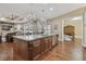 Gourmet kitchen with island seating, hardwood floors, stylish chandeliers, and high-end finishes at 2712 Clubhouse Dr, Plant City, FL 33566