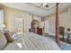 Relaxing main bedroom featuring a four-poster bed, ensuite, and neutral tones at 2712 Clubhouse Dr, Plant City, FL 33566