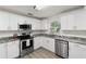 Modern kitchen featuring stainless steel appliances, grey marble counter tops, and white cabinetry at 3119 W North St, Tampa, FL 33614