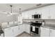 Modern kitchen featuring stainless steel appliances, grey marble counter tops, and white cabinetry with sleek hardware at 3119 W North St, Tampa, FL 33614