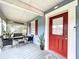 Welcoming front porch with outdoor seating, plants, and a bright red front door for a pop of color at 3213 E Genesee St, Tampa, FL 33610