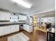 Open kitchen with stainless steel appliances, hardwood floors, and a view of the living and dining areas at 3213 E Genesee St, Tampa, FL 33610
