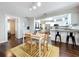 Bright, open space featuring a dining area with a yellow rug and a modern kitchen with white cabinets at 3213 E Genesee St, Tampa, FL 33610