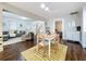 Open concept living and dining area with dark floors, a yellow rug and access to other rooms at 3213 E Genesee St, Tampa, FL 33610