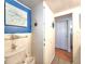 Bathroom featuring blue accent wall with sea-themed art, toilet, and storage closet at 34483 Cactus N Dr, Pinellas Park, FL 33781