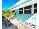 Exterior view of a home featuring turquoise siding, white trim, and palm trees at 34483 Cactus N Dr, Pinellas Park, FL 33781