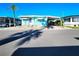 Charming home boasts a vibrant aqua exterior with an attached carport and meticulous landscaping, creating a welcoming ambiance at 34483 Cactus N Dr, Pinellas Park, FL 33781