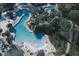 Stunning aerial view of a resort-style pool area with winding walkways, lush landscaping and a slide at 36750 Us 19 N Hwy # 3104, Palm Harbor, FL 34684