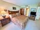 Comfortable bedroom featuring a queen-sized bed, a bedside table, and an armoire at 36750 Us 19 N Hwy # 3104, Palm Harbor, FL 34684