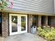 Exterior entryway featuring double doors, a trash receptacle, and well-maintained landscaping at 36750 Us 19 N Hwy # 3104, Palm Harbor, FL 34684
