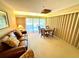 Bright living room area with a large sofa, table, and natural light from a sliding glass door at 36750 Us 19 N Hwy # 3104, Palm Harbor, FL 34684