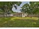 Wide backyard view featuring a well maintained lawn, a wooden deck, a storage shed and a raised garden at 3915 W Leila Ave, Tampa, FL 33616