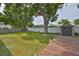 Spacious backyard featuring green grass, large trees, shed, and wood deck at 3915 W Leila Ave, Tampa, FL 33616