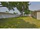 Spacious backyard featuring lush green grass, mature trees providing shade and a wooden deck for outdoor enjoyment at 3915 W Leila Ave, Tampa, FL 33616