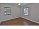 Empty bedroom featuring neutral walls, hardwood floors, and two windows at 3915 W Leila Ave, Tampa, FL 33616