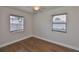 Cozy bedroom with hardwood floors and bright, natural light from two windows at 3915 W Leila Ave, Tampa, FL 33616