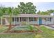 Charming single-story home featuring a well-maintained front yard with vibrant landscaping and a welcoming blue front door at 3915 W Leila Ave, Tampa, FL 33616