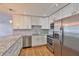 Modern kitchen featuring stainless steel appliances, white cabinets, granite counters, and hardwood floors at 3915 W Leila Ave, Tampa, FL 33616