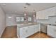 Kitchen with granite island opens to a well-lit living room with hardwood floors and an entryway at 3915 W Leila Ave, Tampa, FL 33616