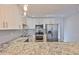 Updated kitchen showcasing granite countertops, stainless steel appliances, white cabinetry, and recessed lighting at 3915 W Leila Ave, Tampa, FL 33616