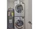 Laundry room features a stacked washer and dryer next to a hot water heater at 3915 W Leila Ave, Tampa, FL 33616