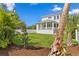 Large backyard with lush green grass, mature trees, and a view of the home's covered back patio at 509 Buckingham E Ave, Oldsmar, FL 34677