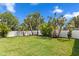 Large, well-maintained backyard featuring lush green grass, palm trees, and a white fence at 509 Buckingham E Ave, Oldsmar, FL 34677