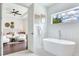 Bathroom featuring a soaking tub and an open doorway to the ensuite main bedroom with sitting area at 509 Buckingham E Ave, Oldsmar, FL 34677