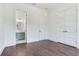 Bright bedroom with dark hardwood floors, white walls and trim, and bathroom with stylish vanity at 509 Buckingham E Ave, Oldsmar, FL 34677