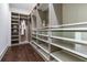 Walk-in closet with custom shelving, glass-front drawers, and ample storage for organization and style at 509 Buckingham E Ave, Oldsmar, FL 34677