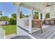 Inviting covered patio with comfortable seating, wood-look flooring, and views of the landscaped backyard at 509 Buckingham E Ave, Oldsmar, FL 34677