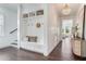 Bright open foyer with a staircase, built-in storage bench, and elegant decor in a modern style at 509 Buckingham E Ave, Oldsmar, FL 34677