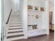 Bright foyer with a staircase and built-in storage bench featuring decorative cushions and baskets at 509 Buckingham E Ave, Oldsmar, FL 34677