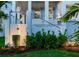 Elegant front yard with lush landscaping, a tranquil fountain, and a charming staircase leading to the porch at 509 Buckingham E Ave, Oldsmar, FL 34677
