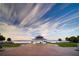 Picturesque gazebo on a brick path overlooking a serene body of water with a beautiful sky at 509 Buckingham E Ave, Oldsmar, FL 34677