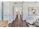 Open hallway with dark wood floors, bright white walls, and modern artwork adding a touch of elegance at 509 Buckingham E Ave, Oldsmar, FL 34677