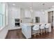 Modern kitchen boasts stainless appliances, white cabinetry, quartz countertops, and a spacious center island at 509 Buckingham E Ave, Oldsmar, FL 34677