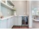Chic pantry with built-in wine cooler, open shelving, and custom cabinetry, enhancing functionality and style at 509 Buckingham E Ave, Oldsmar, FL 34677
