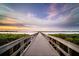 Scenic view of a wooden pier stretching out into the calm water under a colorful sky at 509 Buckingham E Ave, Oldsmar, FL 34677