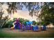 Colorful playground featuring slides, climbing structures, and various play areas surrounded by mature trees at 509 Buckingham E Ave, Oldsmar, FL 34677