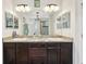 This bathroom features a granite double vanity with dark wood cabinets at 513 Harbor Springs Dr, Palm Harbor, FL 34683