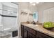 Well-lit bathroom featuring a granite-topped vanity, decorative lighting, and a shower-tub combo at 513 Harbor Springs Dr, Palm Harbor, FL 34683