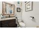 Cozy powder room features granite countertop, dark wood vanity, decorative mirror, and elegant coastal decor at 513 Harbor Springs Dr, Palm Harbor, FL 34683