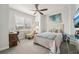 Bright bedroom features a ceiling fan, large window, and a cozy bed with stylish decor at 513 Harbor Springs Dr, Palm Harbor, FL 34683