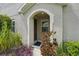 Charming entryway with arched doorway and lush landscaping at 513 Harbor Springs Dr, Palm Harbor, FL 34683