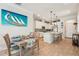 Bright eat-in kitchen features white cabinets, tile backsplash, stainless steel appliances, and an island with seating at 513 Harbor Springs Dr, Palm Harbor, FL 34683