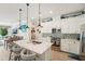 Bright eat-in kitchen features white cabinets, tile backsplash, stainless steel appliances, and an island with seating at 513 Harbor Springs Dr, Palm Harbor, FL 34683